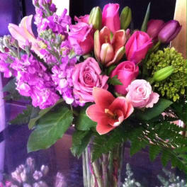 Pink and purple mixed bouquet with lilies and roses in a clear glass vase