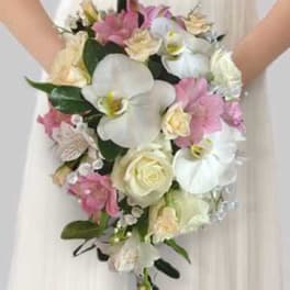 Bride holding a bouquet of white orchids, roses, and pink flowers