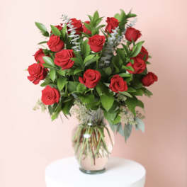 Red roses arranged in a clear glass vase