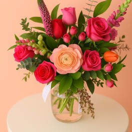 Bouquet of pink and peach roses in a clear glass vase