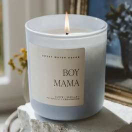 Lit white candle in a glass jar labeled Boy Mama