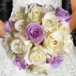 Bouquet of white and lavender roses held against a white dress