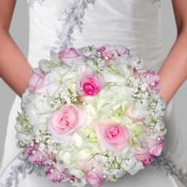 Bride holding a round bouquet of pink and white roses