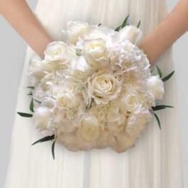 Bride holding a white rose bouquet with soft white blooms