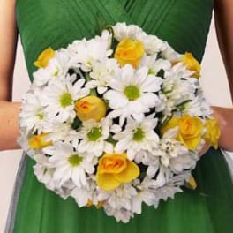 Bouquet of white daisies and yellow roses held against a green dress