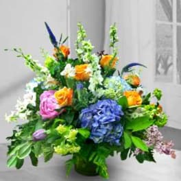 Colorful mixed flower arrangement in a low green vase