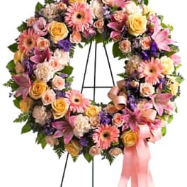Floral wreath with pink and yellow flowers on a stand