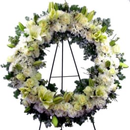 Large white floral wreath on a black stand