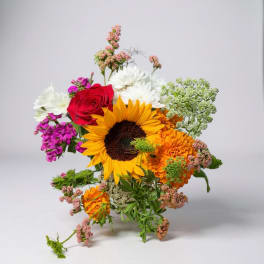 Mixed bouquet with a sunflower, red rose, and orange and white blooms