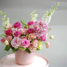 Pink and white floral arrangement in a blush vase