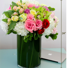 Mixed pink, white, and red roses in a tall green vase