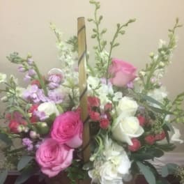 Basket arrangement of pink and white roses with lavender flowers