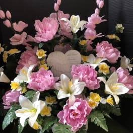 Pink and white floral arrangement with an angel plaque in a white vase