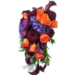 Cascade bouquet of orange roses, purple blooms, and dark calla lilies