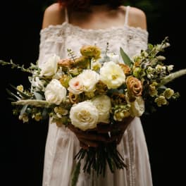 Bride holding a loose bouquet of cream and blush roses