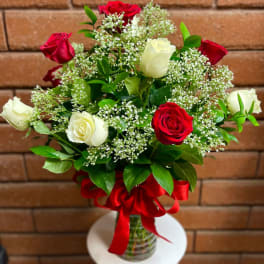 Bouquet of red and white roses with baby's breath in a glass vase