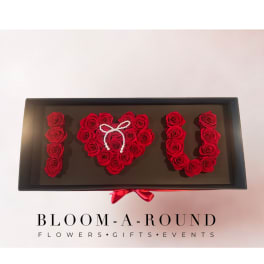 Red roses arranged as "I ♥ U" in a black gift box