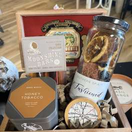 Gift basket with candles, chocolates, and a jar of dried fruit