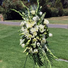 Tall white floral standing spray on an easel outdoors