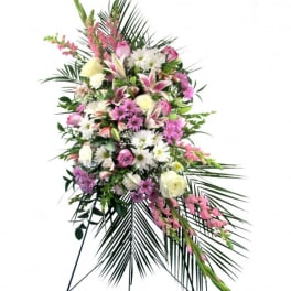 Standing floral spray with pink and white flowers on a black easel