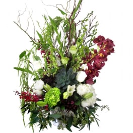 Tall floral arrangement with burgundy orchids, white blooms, and a succulent