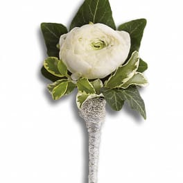 White ranunculus boutonniere with green leaves and silver wrap