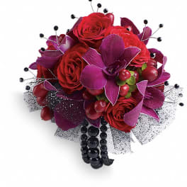 Red roses with purple orchids and black bead accents in a bouquet