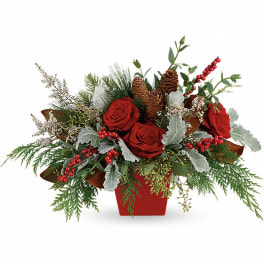 Red roses in a red container with pinecones and winter greenery