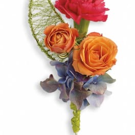 Boutonniere with orange roses, a pink carnation, and blue hydrangea