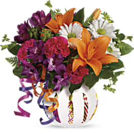 Colorful bouquet with lilies, daisies, and carnations in a decorated vase