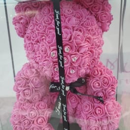 Pink rose teddy bear in a clear gift box with a black ribbon