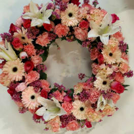 Circular floral wreath with pink, peach, and white flowers