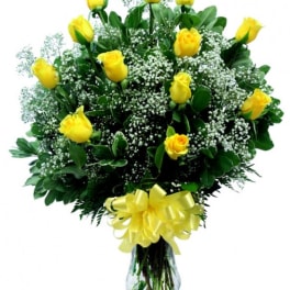 Yellow roses in a glass vase with baby's breath and a yellow bow