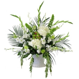 White and green floral arrangement in a white vase