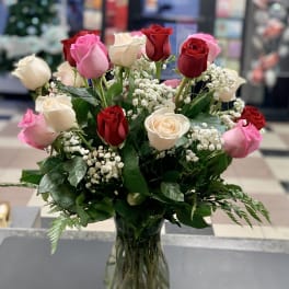 Bouquet of red, pink, and white roses in a clear glass vase