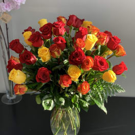 Bouquet of red and yellow roses in a clear glass vase