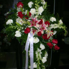 Standing floral spray with red roses, pink lilies, and white blooms