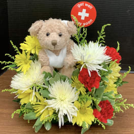 Teddy bear surrounded by yellow, white, and red flowers with a get well sign