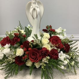 Red and white rose arrangement with a praying angel statue