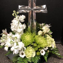 White and green floral arrangement with a glass cross centerpiece