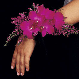 Pink orchid wrist corsage on a person's wrist