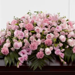 Pink floral casket spray with roses, lilies, and carnations