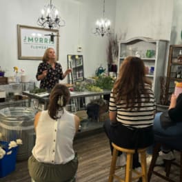 People seated in a flower shop during a floral workshop
