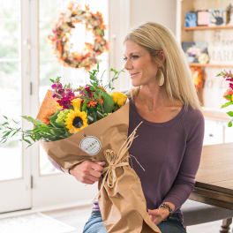Woman holding a wrapped bouquet of mixed flowers