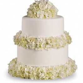 Three-tier white cake covered with white flowers