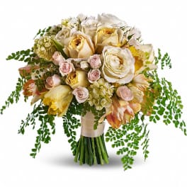 Bouquet of cream and pale pink roses with trailing greenery