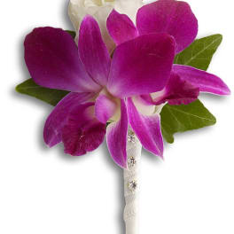 Purple and white orchid boutonniere with green leaves