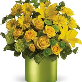 Yellow roses and lilies in a green vase