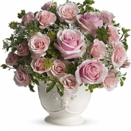 Pink roses arranged in a white ceramic vase