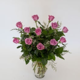 Pink roses arranged in a clear glass vase